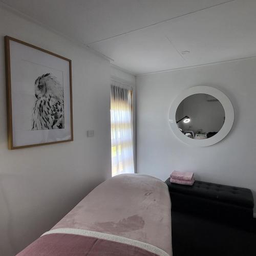 Primrose SandsPrimrose Seaside Healing Retreat的卧室配有一张床,墙上设有镜子