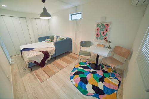 东京Orange County in Shinjuku的卧室配有1张床、1张桌子和1把椅子