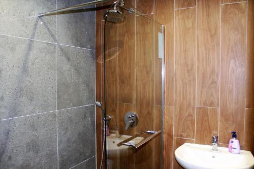 波罗维茨波罗维茨花园公寓PM服务酒店的带淋浴和盥洗盆的浴室