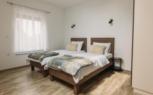 PišeceHiša na Ravnah的白色卧室配有一张带两个枕头的大床