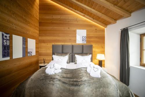 弗坦Chasa Sömmi的一间卧室配有一张带木墙的大床