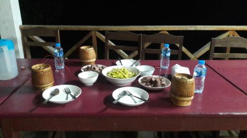 孟丰沙湾Ban Na Pia - Family Home stay的一张桌子,上面放着一碗食物和瓶装水