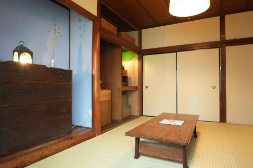 尾道市つばめ荘 Tsubamesou的客厅配有桌子和梳妆台