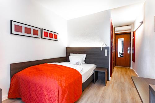 纽伦堡艺术商务酒店的一间卧室配有一张带橙色毯子的床