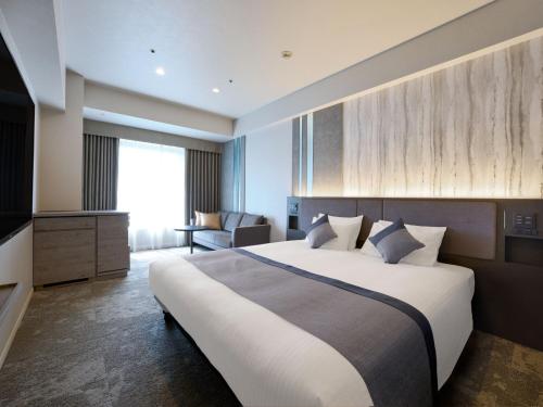 东京Hotel Villa Fontaine Grand Tokyo-Shiodome的酒店客房设有一张大床和一台电视。