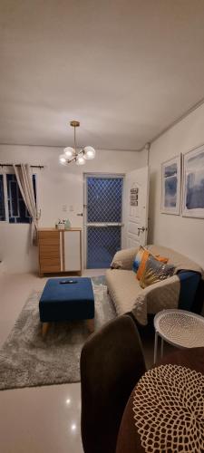 武端市Cassie Homestay - Yuna Door 2 - Furnished Home in Butuan的客厅配有沙发和桌子