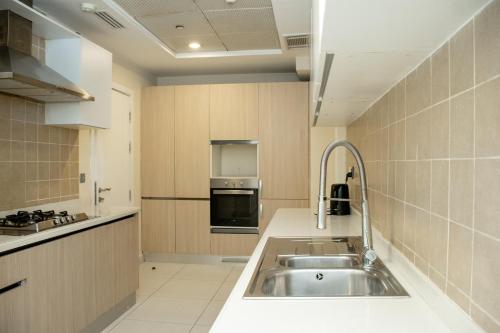 伊斯兰堡Centaurus Hotel Suites的厨房配有水槽和炉灶