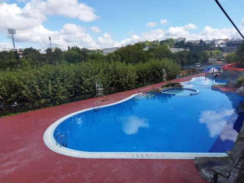 卢戈Lazzaretto vivienda uso turístico的一座大型蓝色游泳池,位于一座建筑的顶部