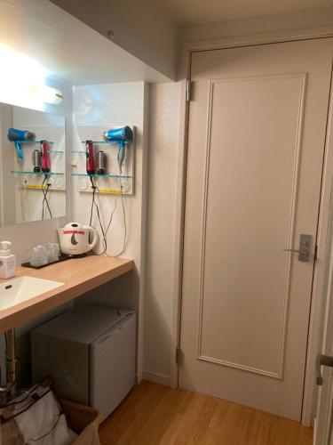 金泽城镇41胶囊旅馆的浴室设有白色门和水槽