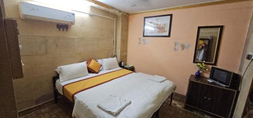 斋沙默尔Nomadic Backpackers Hostel的一间小卧室,配有一张床和电视