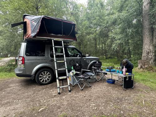InshesDiscovery 4 - Family Camper的卡车后面有帐篷的露营车