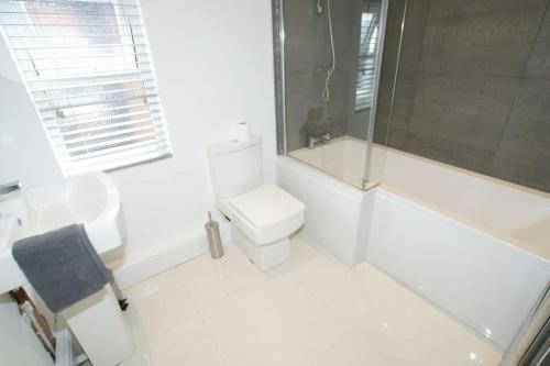 切斯特Modern 4 bed house near city centre/Chester Zoo的白色的浴室设有卫生间和淋浴。