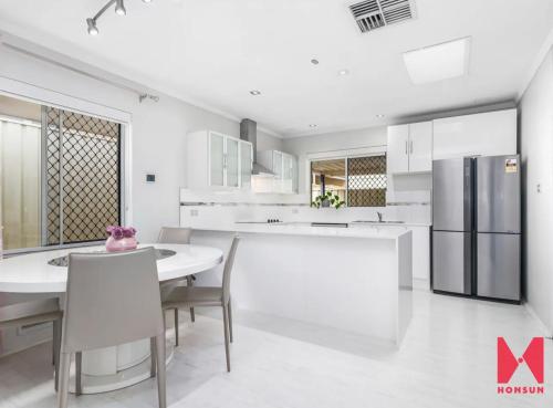 珀斯Leisurehome的白色的厨房配有桌子和冰箱