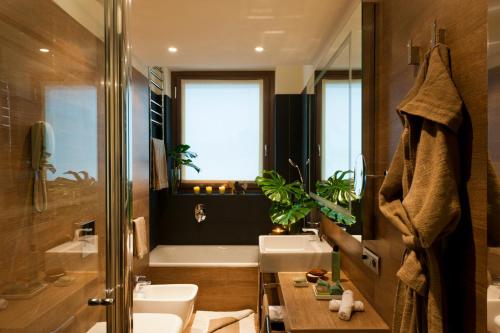 米兰星际埃科酒店的浴室配有盥洗盆、卫生间和浴缸。