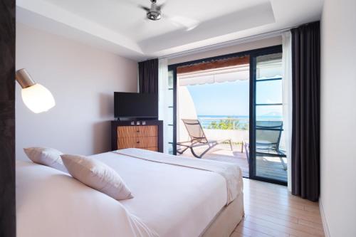 普纳奥亚Te Moana Tahiti Resort的一间卧室配有一张床,享有海景