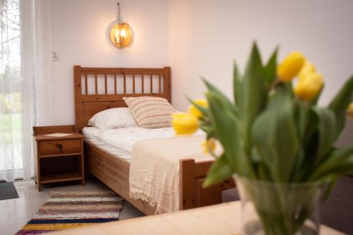 Zubrzyca DolnaZubrzyckie Pokoje的一间卧室配有床和黄色花瓶