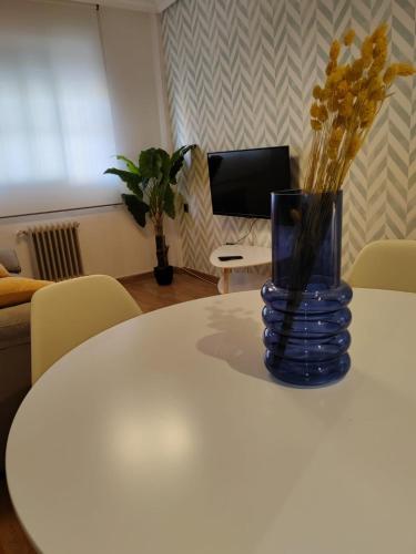 阿尔巴塞特Urbanlux Hospital II的花瓶坐在白色桌子上,里面装着鲜花