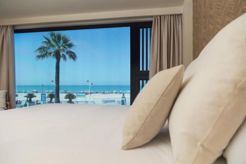 加的斯Apartamentos Playa Victoria的一间卧室设有一张床,享有海景