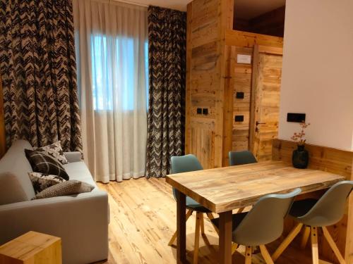布勒伊-切尔维尼亚Fior di Roccia Apartments的客厅配有木桌和椅子