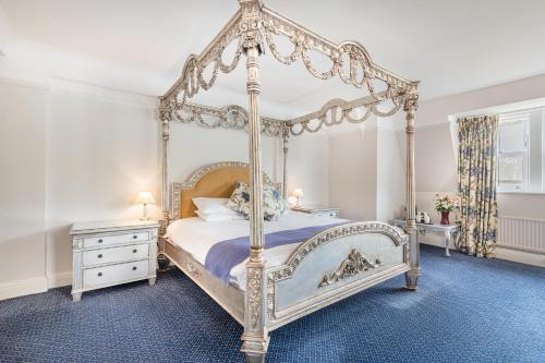 肯德尔河畔酒店的一间卧室配有一张天蓬床和梳妆台