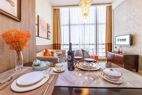 广州广州正佳金殿维福顿公寓（广交会期间免费穿梭巴士）的客厅配有带盘子和酒杯的桌子