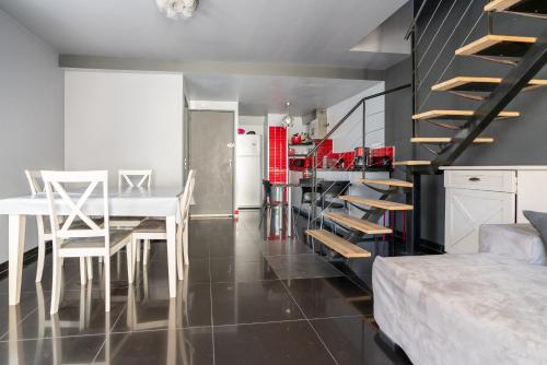 勒格罗-迪鲁瓦appartement de la barque bleue的厨房以及带餐桌和楼梯的用餐室。