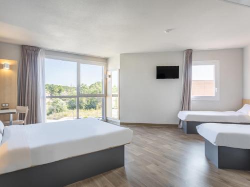 沃内勒B&B HOTEL Aix en Provence Venelles的酒店客房设有两张床和窗户。
