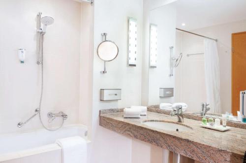 德累斯顿德累斯顿新城NH酒店的白色的浴室设有水槽和淋浴。