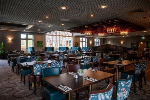 利明顿温泉农庄林地酒店的用餐室配有木桌和椅子