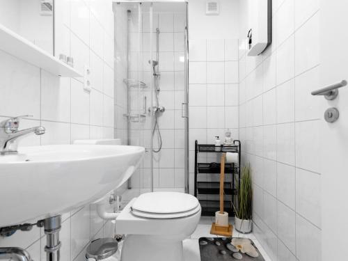 埃森# VAZ Apartments E01 Küche, TV, Netflix, ca 15 Min Messe u HBf的白色的浴室设有卫生间和水槽。