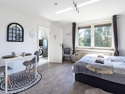 埃森# VAZ Apartments E01 Küche, TV, Netflix, ca 15 Min Messe u HBf的卧室配有一张床、一张书桌和窗户。