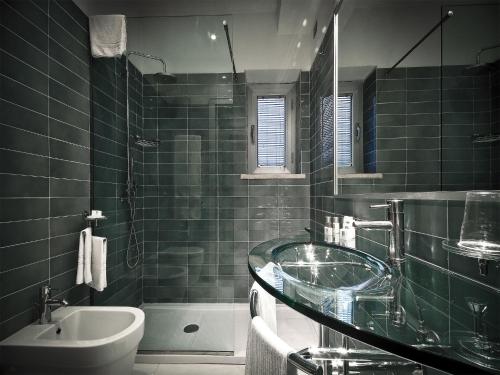 罗马全时瑞雷斯及运动酒店的一间带玻璃水槽和浴缸的浴室
