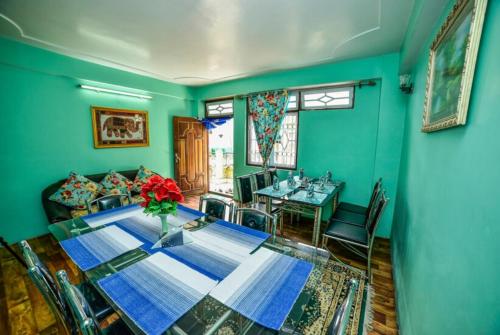 GhumGRG Tharbaling Homestay Darjeeling的一间带桌子和沙发的用餐室