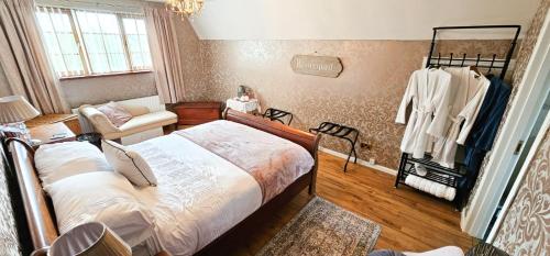 纽敦纳兹Drumhirk House的一间卧室配有一张床、一把椅子和一张沙发