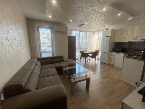 普罗夫迪夫Cozy-1BD Flat的带沙发和桌子的客厅以及厨房。
