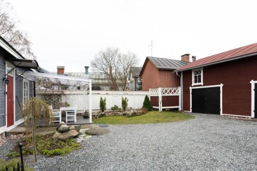 劳马Idyllic house in Old Rauma的后院设有红色房子和白色围栏
