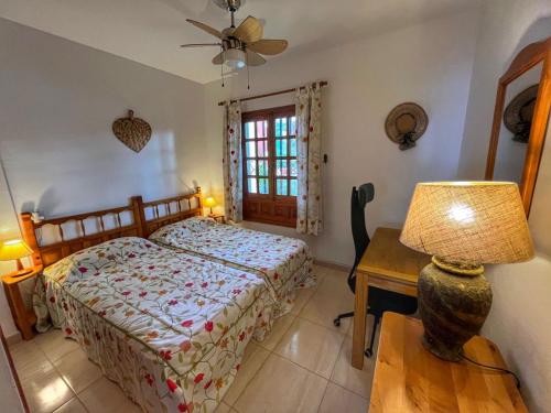 圣地亚哥港Puertito Varadero的一间卧室配有一张床和一张带台灯的桌子