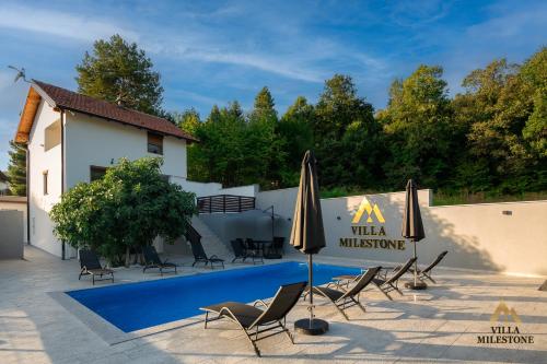 Villa Milestone Majevica的别墅 - 带带椅子和遮阳伞的游泳池