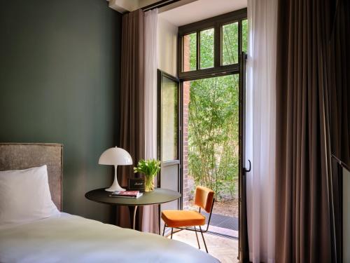 柏林sly Berlin的一间卧室配有一张床、一张桌子和一个窗户。