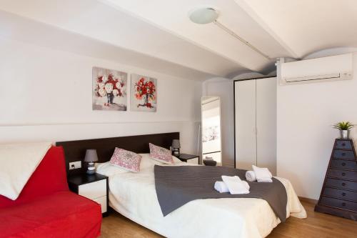 巴塞罗那Key Gracia Apartments的一间卧室配有一张床和一张红色椅子