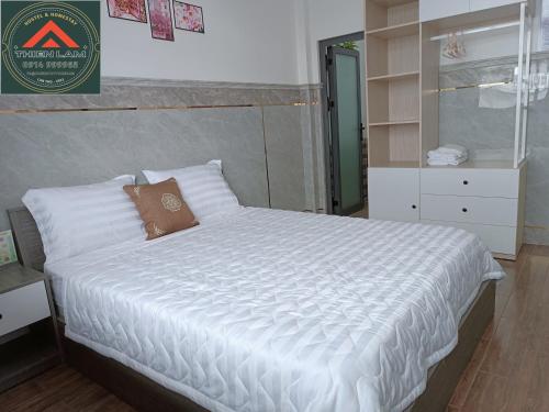 芹苴Thiên Lam Homestay的一间卧室配有一张带白色床单的大床