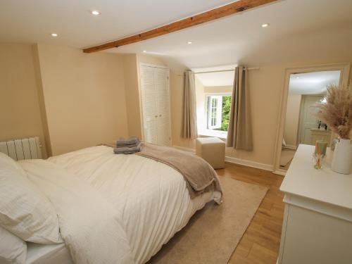什鲁斯伯里Bluebell's Cottage的卧室配有白色的床和窗户。