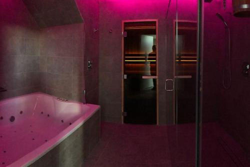 巴利巴宁Slate House的粉红色的浴室设有浴缸和淋浴。