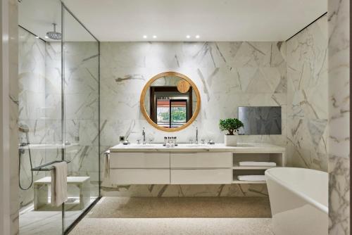 罗克布吕讷-卡普马丹蒙特卡洛海滩酒店的一间带水槽、浴缸和镜子的浴室