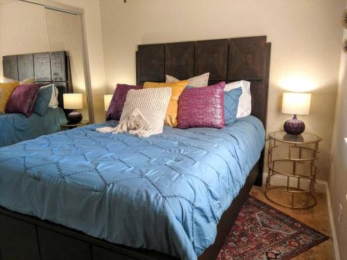 温泉城Perfect Lake Retreat的一张带蓝色棉被和色彩缤纷的枕头的床