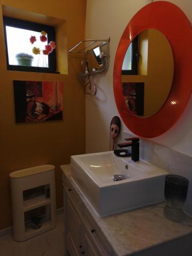 Saint-Féliu-dʼAvallMaison d'Art' lette的浴室设有白色水槽和红色镜子