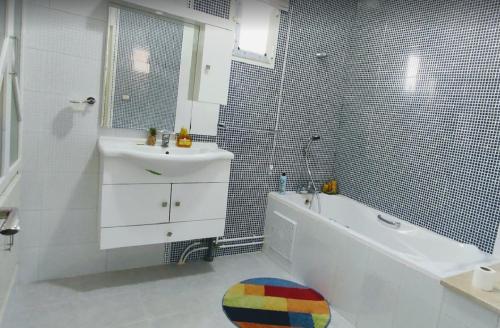 泰塔温Villa Mimosa Tataouine的浴室配有白色浴缸、盥洗盆和浴缸。