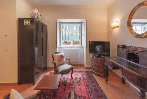 辛特拉Villa Estefânia em Sintra的客厅配有书桌、电视和椅子