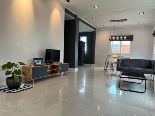 闵埔丽Happy home บ้านกว้าง ได้ทั้งหลัง ไวไฟฟรี1000Mbps ใกล้สนามบินสุวรรณภูมิ的带沙发和电视的客厅