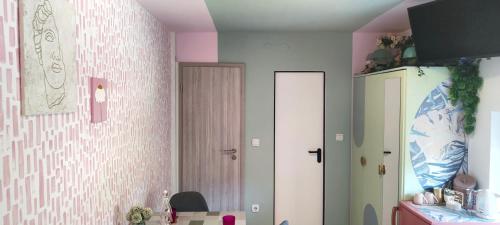 博德森特克Apartments & rooms Saša的厨房设有粉红色和白色的墙壁和冰箱。